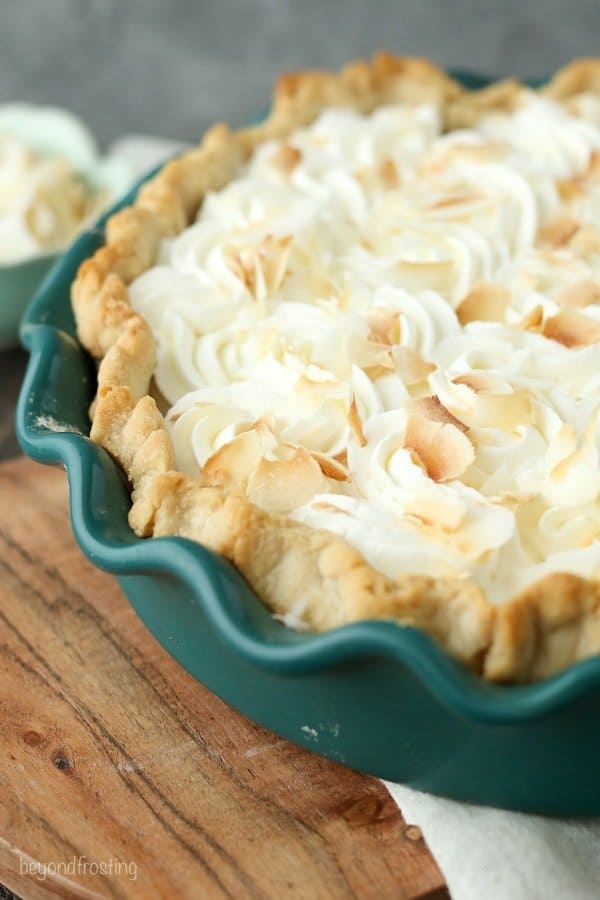 A Coconut Cream Pie in a Green Ceramic Dish