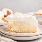 Side view of a slice of coconut cream pie on a plate.