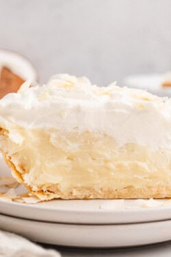 Side view of a slice of coconut cream pie on a plate.