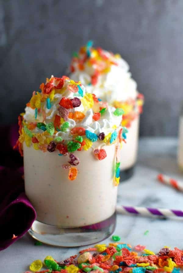 Two Fruity Pebbles Boozy Milkshakes with Red and Purple Striped Straws