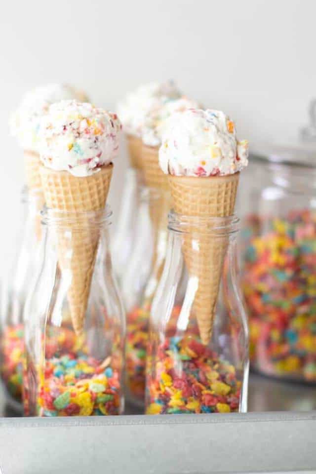 Four Cones of Fruity Pebbles Ice Cream Held Up in Four Glass Bottles