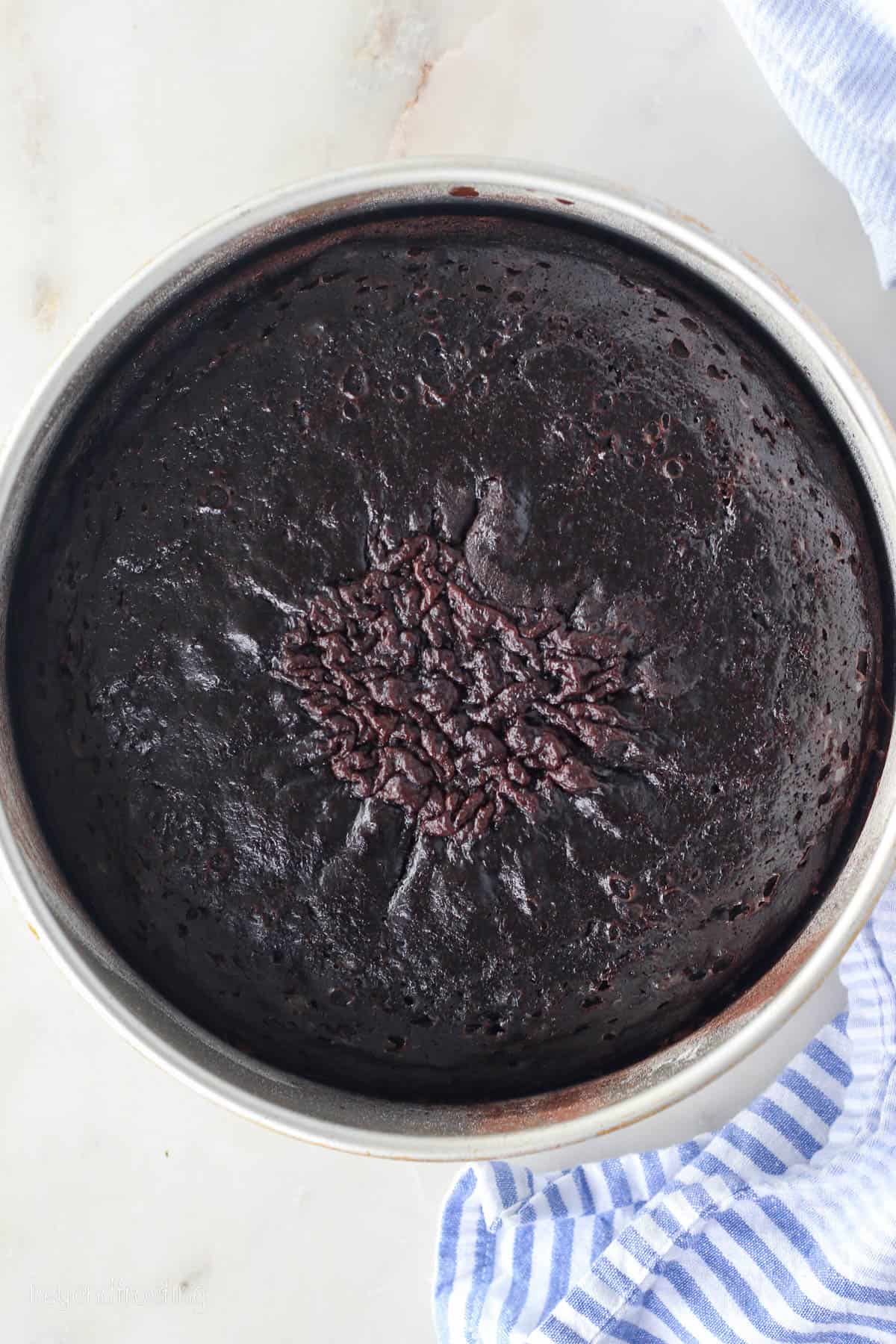 Baked chocolate zucchini cake in a round cake pan.