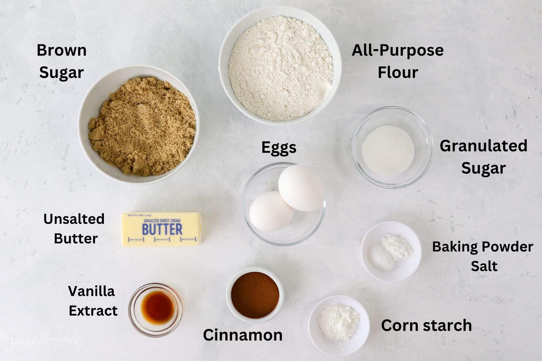 Ingredients for cinnamon roll blondies with text labels over each ingredient.