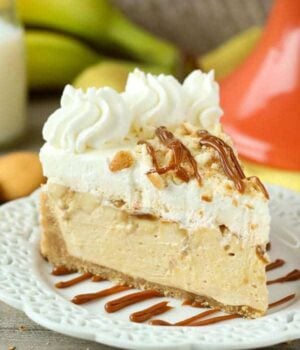 This No-Bake Banana Dulce De Leche Mousse Cake is layers of dulce de leche mousse and fresh sliced banana under a layer of banana pudding mousse with a Nilla wafer crust and whipped cream on top.