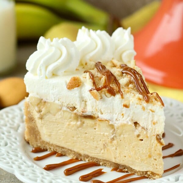 This No-Bake Banana Dulce De Leche Mousse Cake is layers of dulce de leche mousse and fresh sliced banana under a layer of banana pudding mousse with a Nilla wafer crust and whipped cream on top.