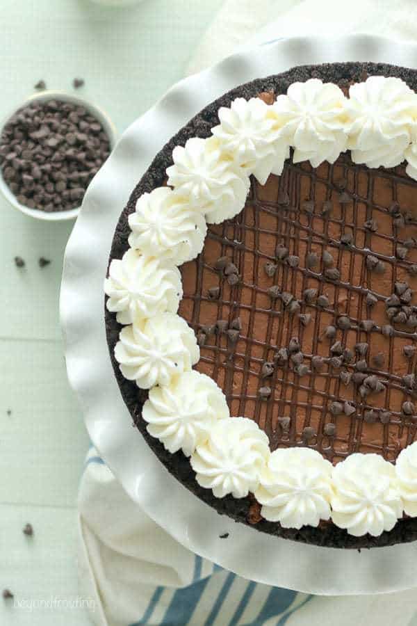 An overhead shot of a chocolate pudding pie on a white cake plate