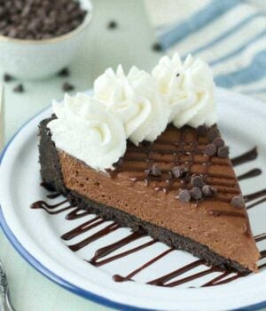 A slice of Kahlua pie on a plate with chocolate chips and whipped cream