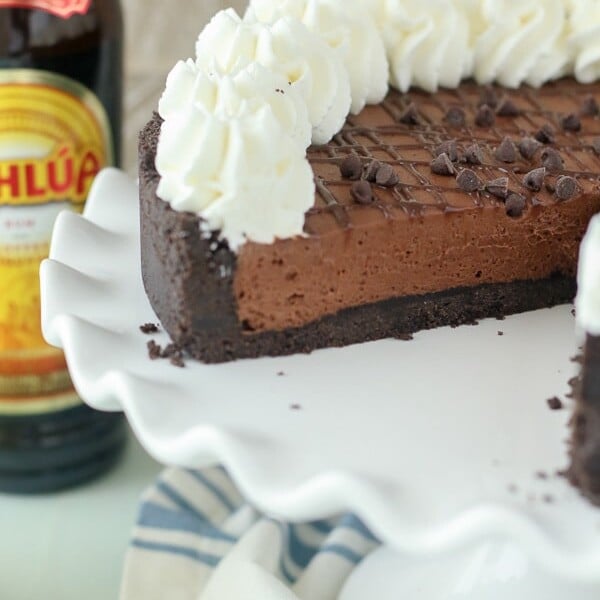 A picture of a no-bake Kahlua pie on a white cake plate with a slice taken out of it