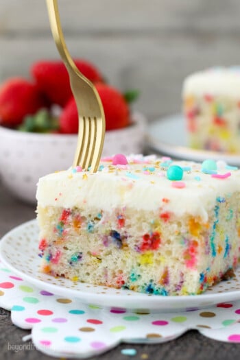 A fork digging into a slice of funfetti cake.
