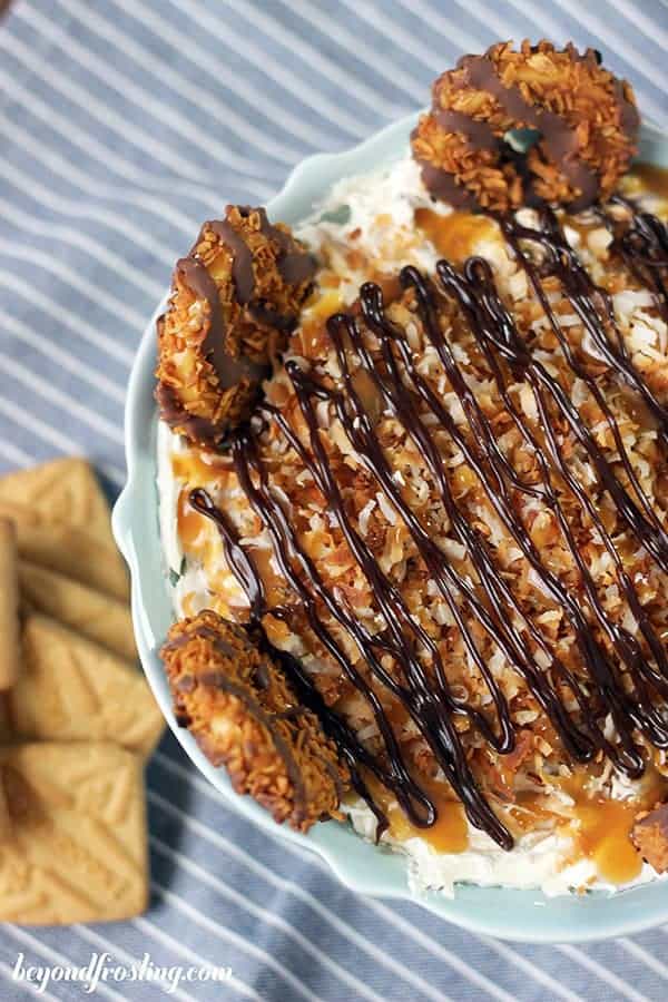 An overhead shot of a samoa dip with hot fudge and caramel drizzled over toasted coconut