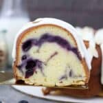 A sliced of swirled blueberry almond pound cake on a gold pie serving spatula
