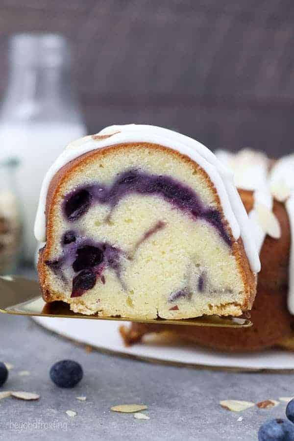 A sliced of swirled blueberry almond pound cake on a gold pie serving spatula