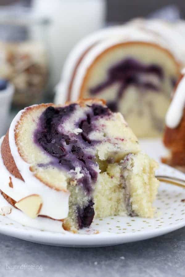 A slice of blueberry pound cake with a few bites taken out of it.