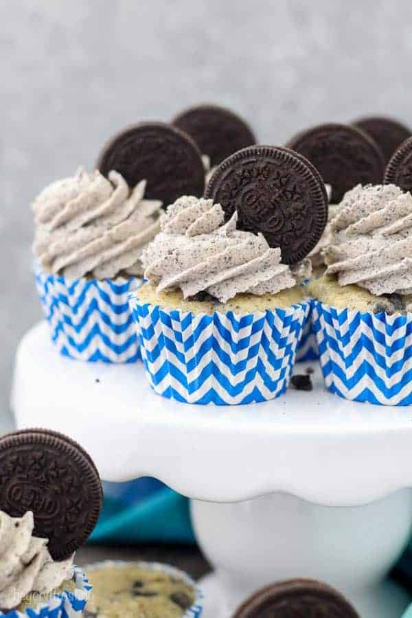 A few Cookie and Cream Oreo Cupcakes sitting on a white cake plate