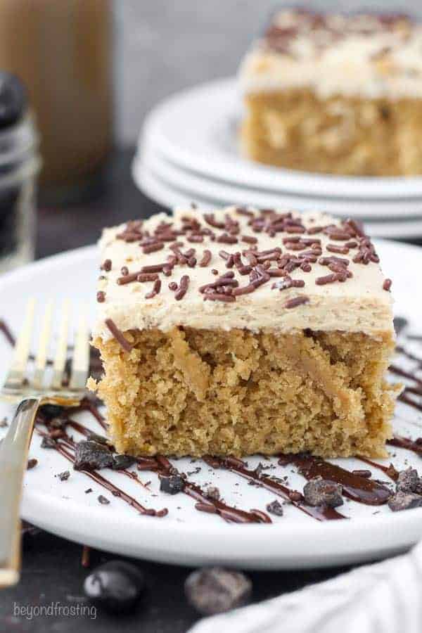  Un denso pan di spagna moka con una glassa di Kahlua e caffè condita con granelli di cioccolato. La fetta di torta è su un piatto di torta bianca condita con cioccolato.