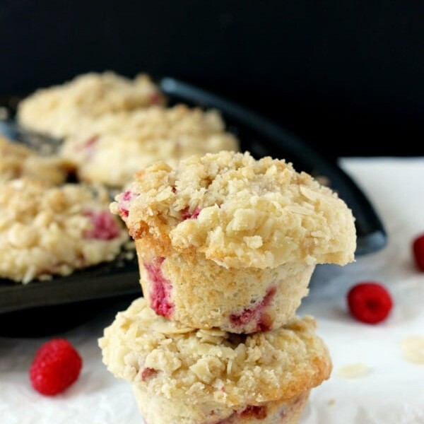 Two large bakery style muffins stuffed with raspberries and bursting with lemon flavor and topped with an almond streusel.