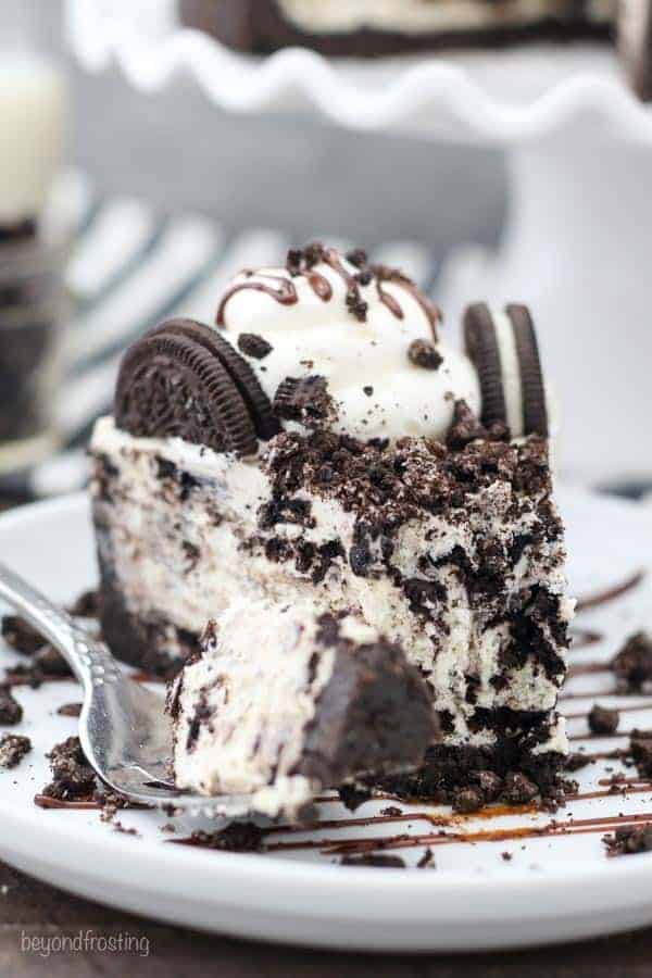 A slice of no-bake cheesecake loaded with Oreos with a giant bite taken out of it.