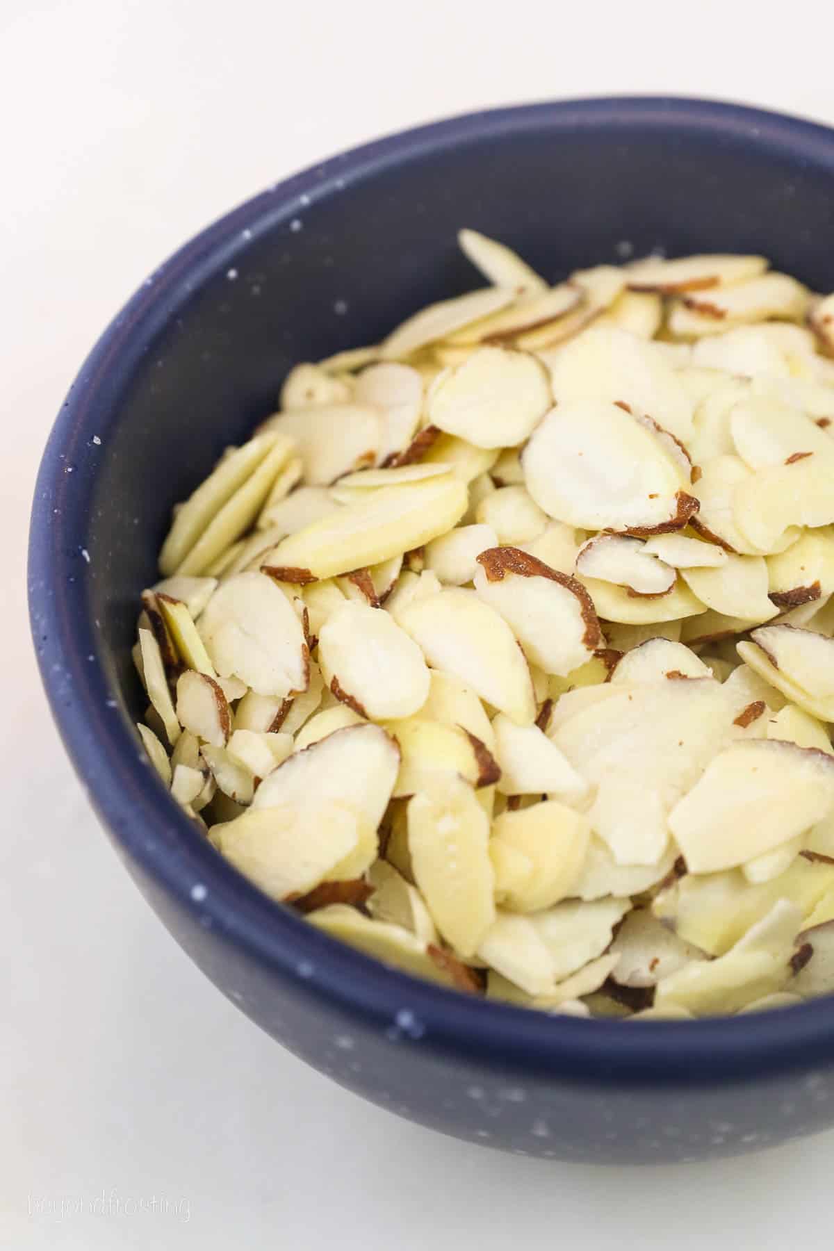 Slivered almonds in a blue bowl.