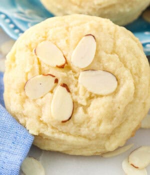 Close up of a almond cookie decorated with sliced almonds.