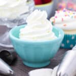 A teal dish filled with a piped whipped cream swirl.