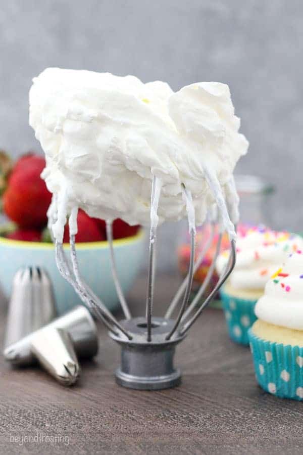 A shot of a wire whisk with whipped cream