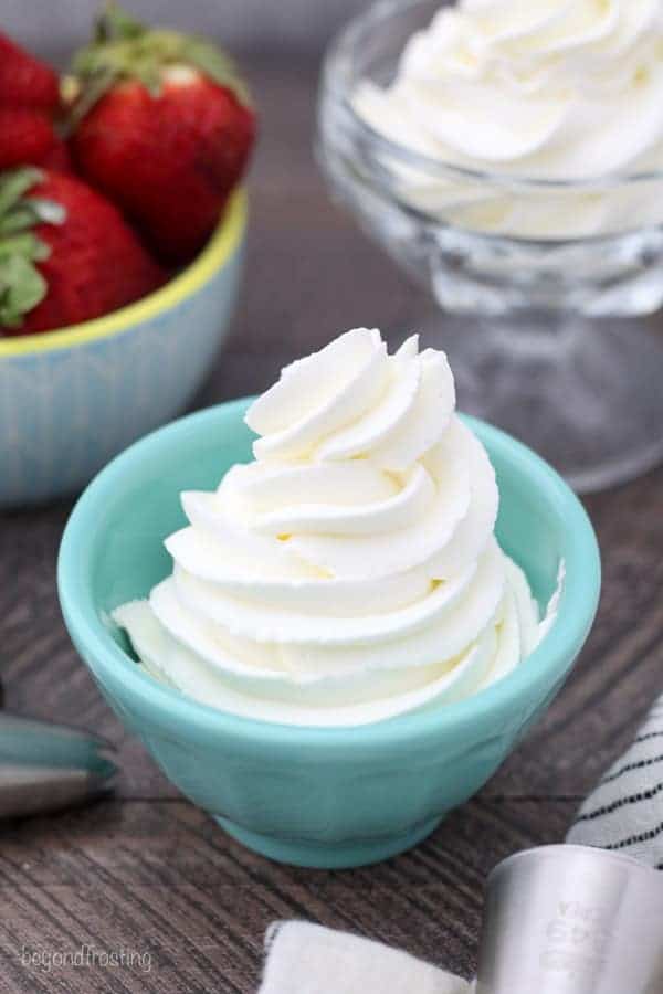 An overhead shot of pipped whipped cream in a teal dish