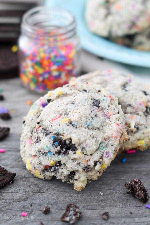 These cookies are stacked up against one another and have chunks of Oreos and sprinkles inside.
