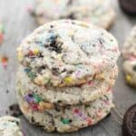 Three stacked cookies that are stuffed with Oreos and sprinkles.
