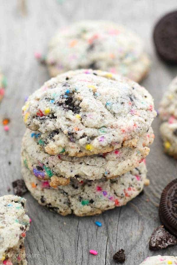 Three stacked cookies that are stuffed with Oreos and sprinkles.