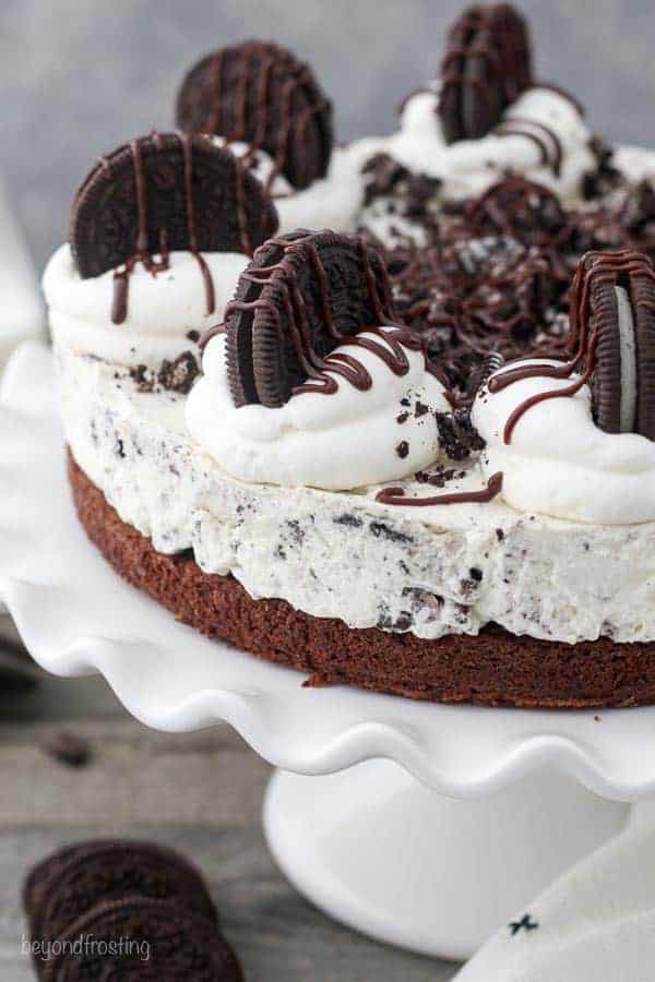 A whole Oreo Brownie Mousse Pie on a white cake plate with a scallop edge