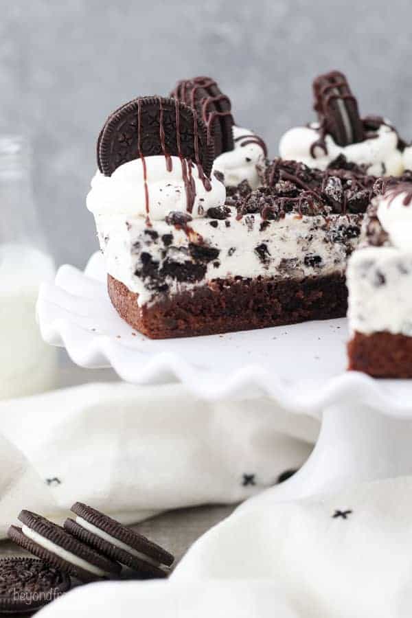 An Oreo Brownie Mousse Pie with a big slice taken out of it, sitting on a white cake plate