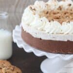 A close up of a chocolate chip cookie mousse cake on a white cake plate