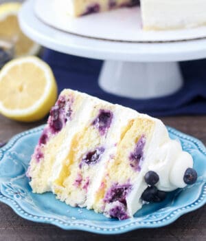 Slice of lemon blueberry layer cake on a blue plate