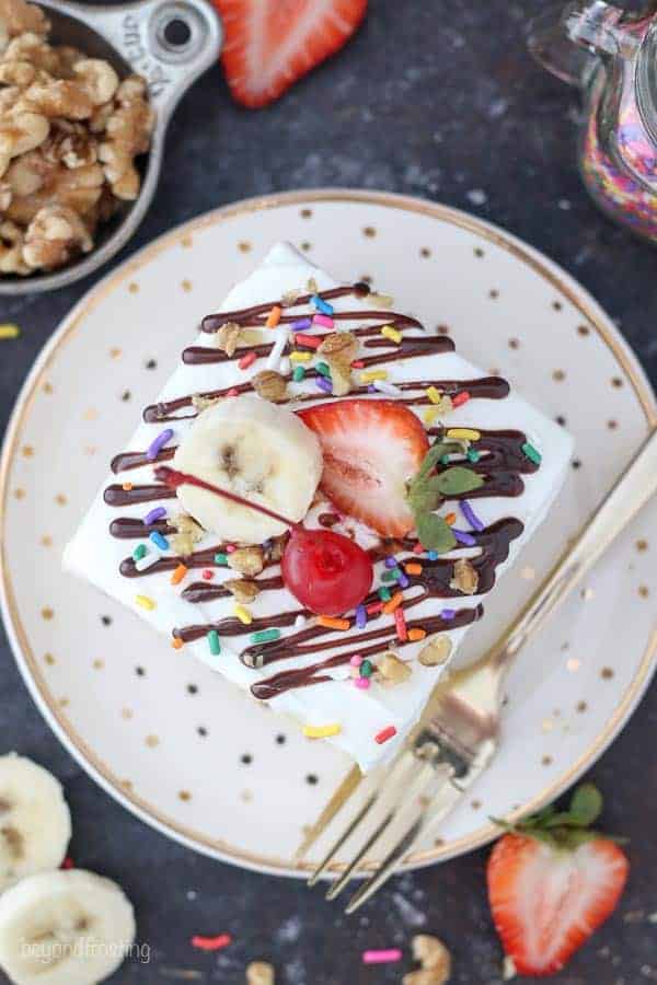 An overhead shot of a colorful splice of cake on a gold polka dot cake plate