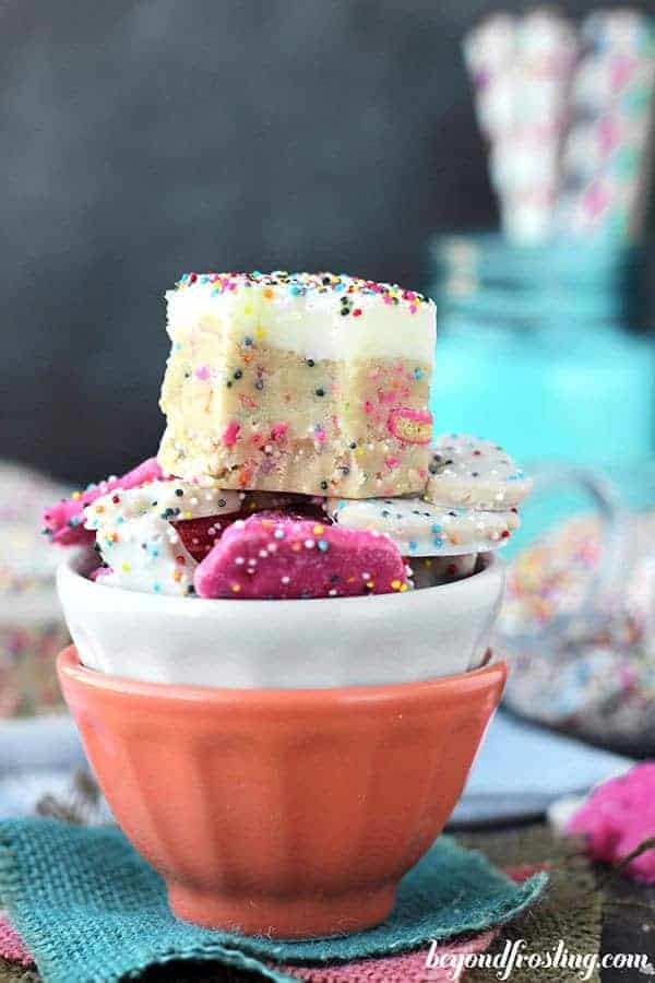 A cookie dough bar with a truffle topping is stacked on top of a bowl of Circus Animal Cookies