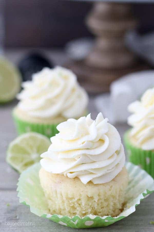 A beautiful margarita cupcake with lime frosting, and a green polka dot cupcake liner with the sides peeled away