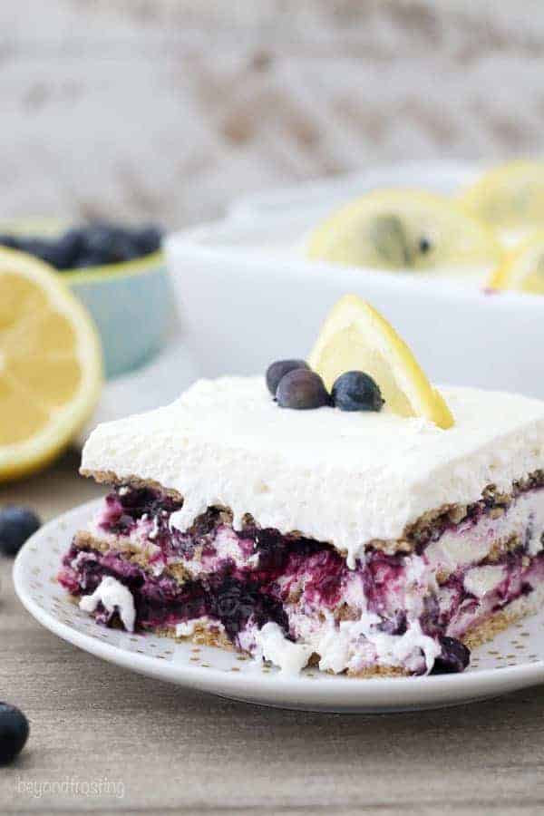 A mouthwatering layered icebox cake with blueberries and a lemon wedge on top.