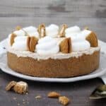 A horizontal photo of an a whole ice cream pie topped with whipped cream and oatmeal cream pies