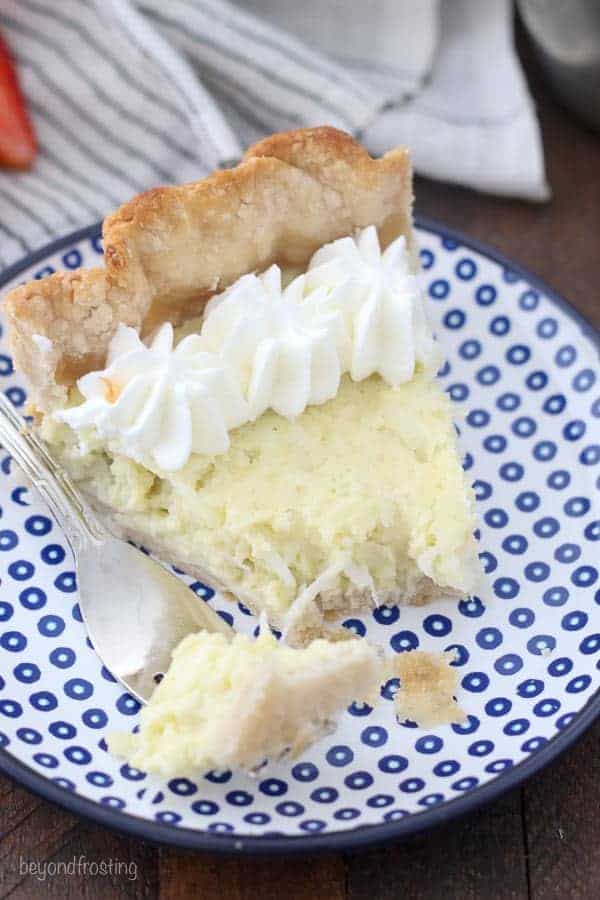 A slice of coconut pie with a couple of bites missing