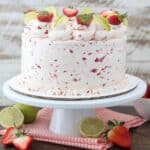 A three layer tequila vanilla cake with a strawberry frosting. This cake is garnished with sliced strawberries and lines