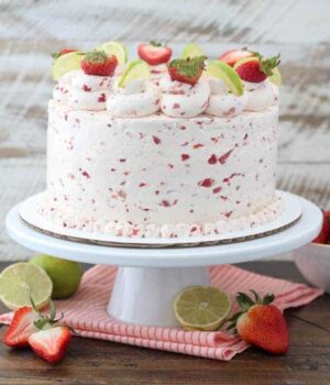 A three layer tequila vanilla cake with a strawberry frosting. This cake is garnished with sliced strawberries and lines
