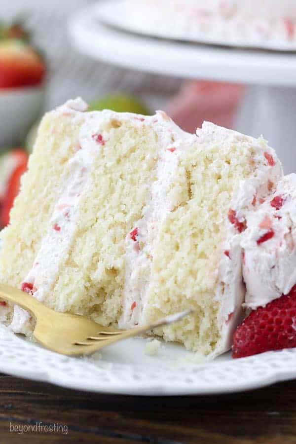 A close up on a three layer margarita cake with bites taken out of it