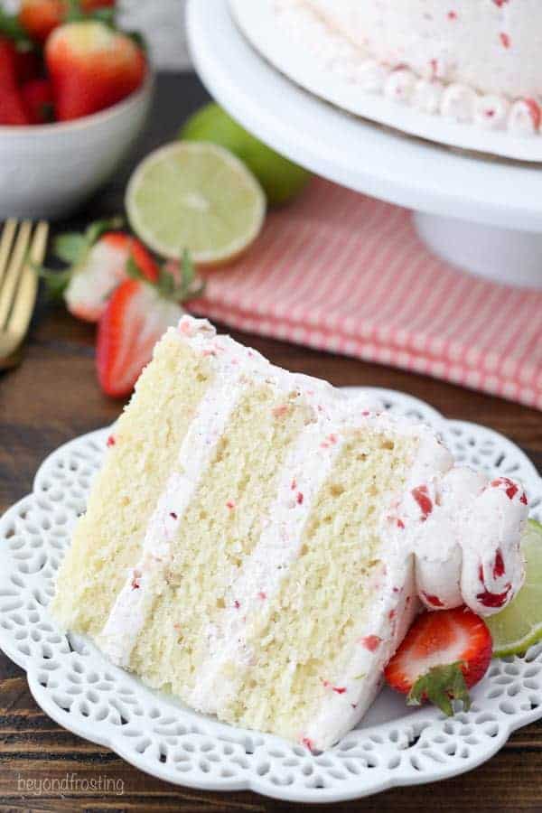 An overhead shot of a 3 layer strawberry margarita cake. The frosting is light pink with pieces of strawberries in it.