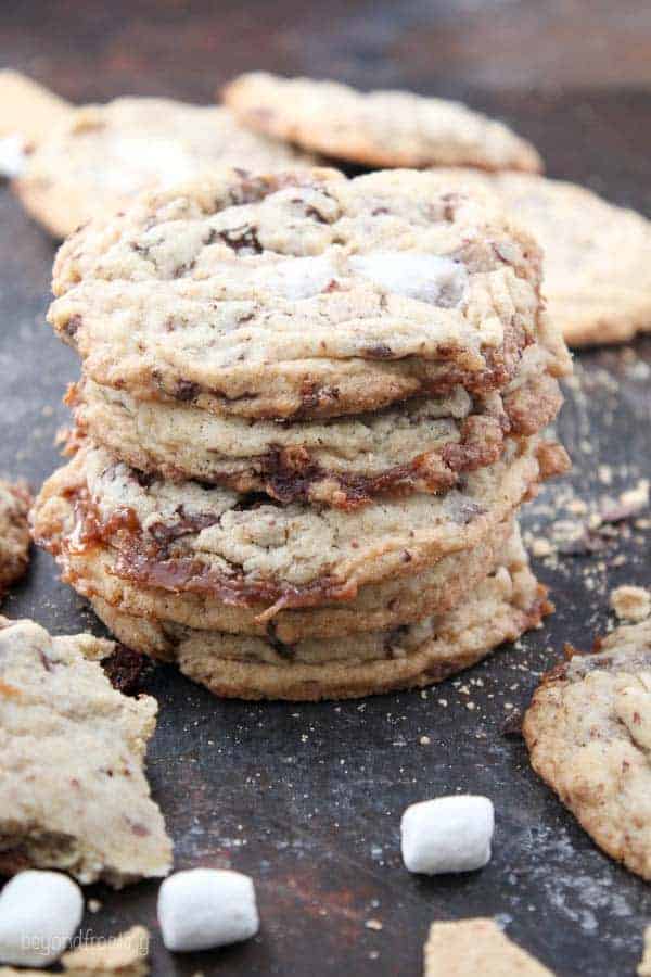 A stack of cookies with burnt sugar edges styles with mini marshmallows on a cookie sheet