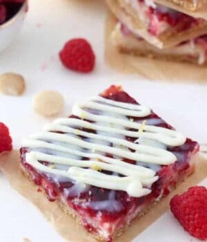 An overhead shot of a raspberry seven layer bars with a white chocolate drizzle