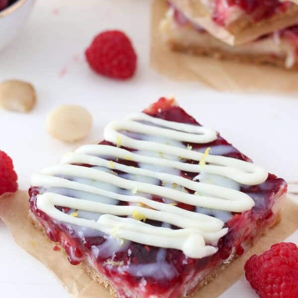 An overhead shot of a raspberry seven layer bars with a white chocolate drizzle