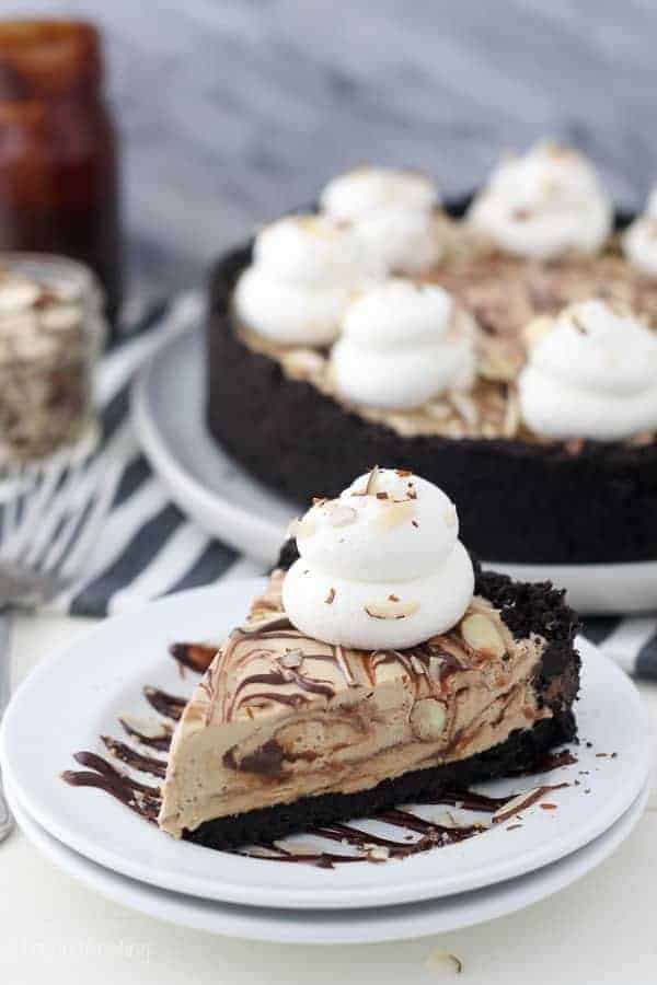 An overhead shot of a slice of mocha fudge pie on a white cake plate drizzled with hot fudge sauce