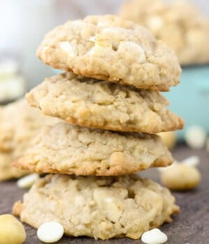 A stack of four oatmeal white chocolate macadamia nut cookies.