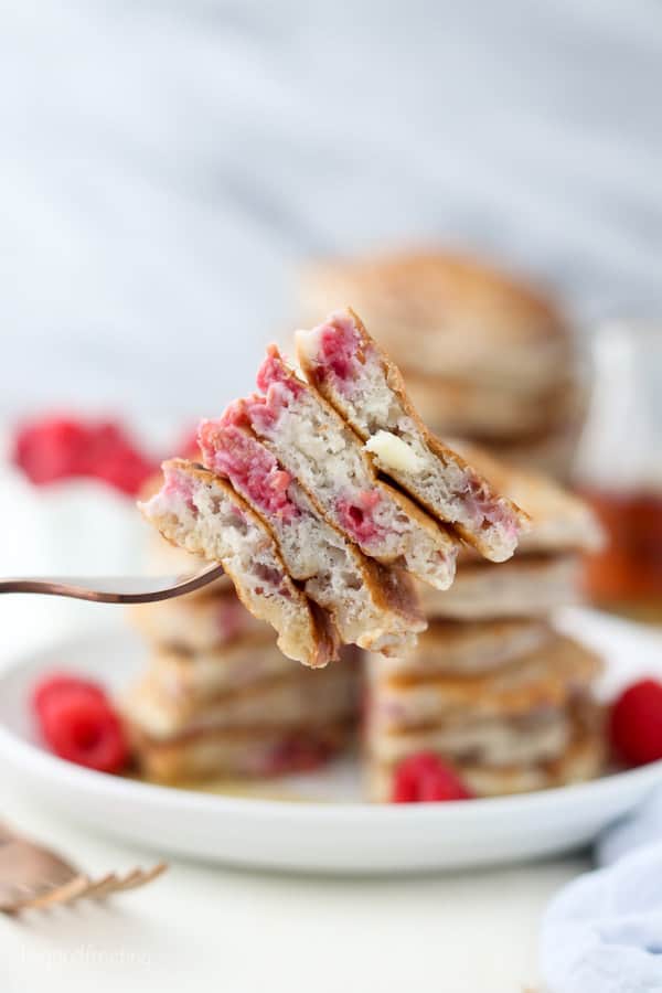 A fork loaded with bites of raspberry pancakes