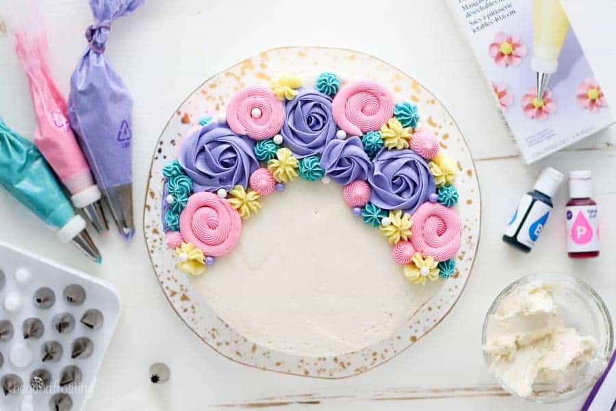 An overhead view of a cake decorated with buttercream roses and buttercream flowers